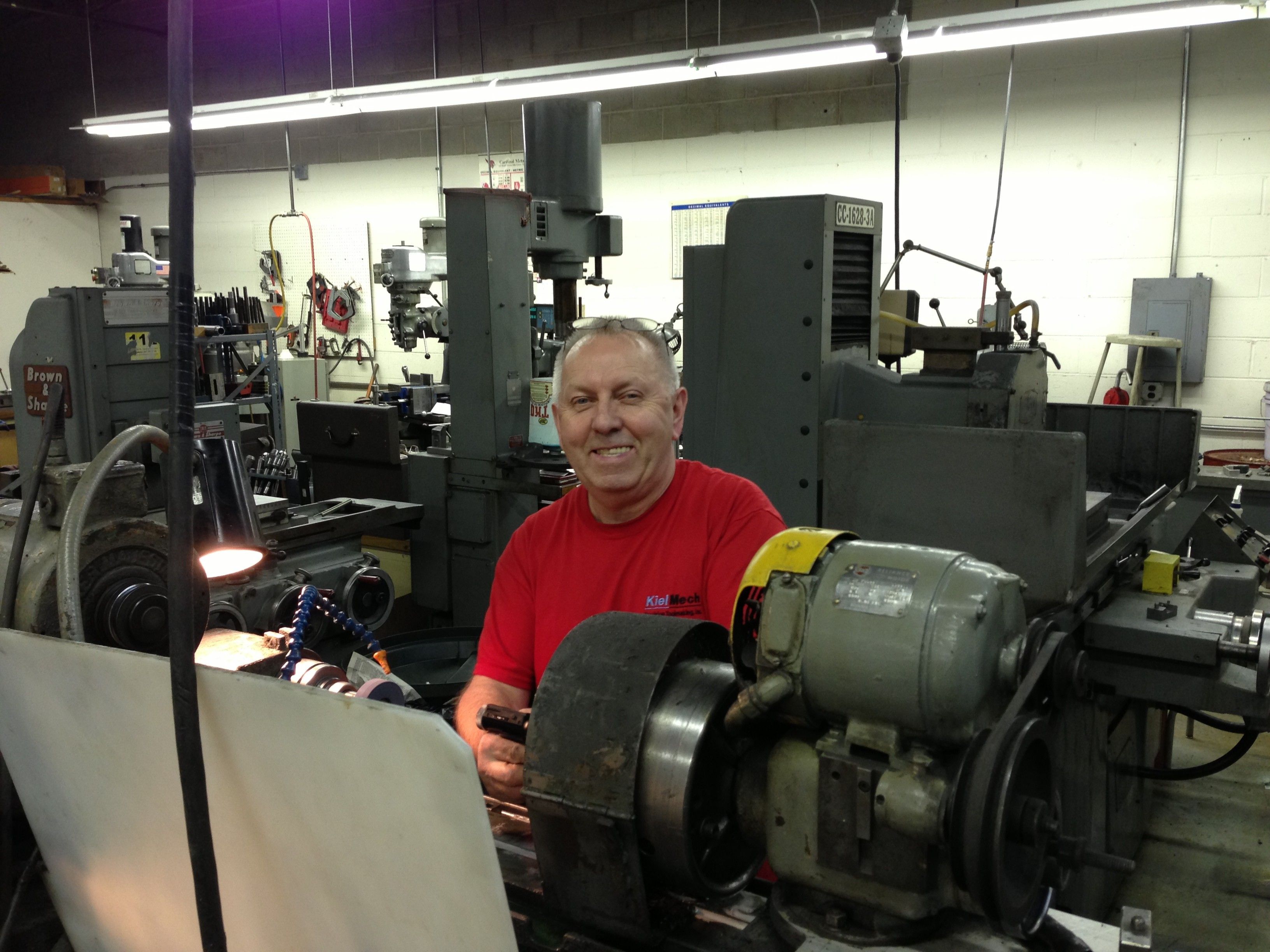 Founder of KielMech standing at a grinding machine in the shop
